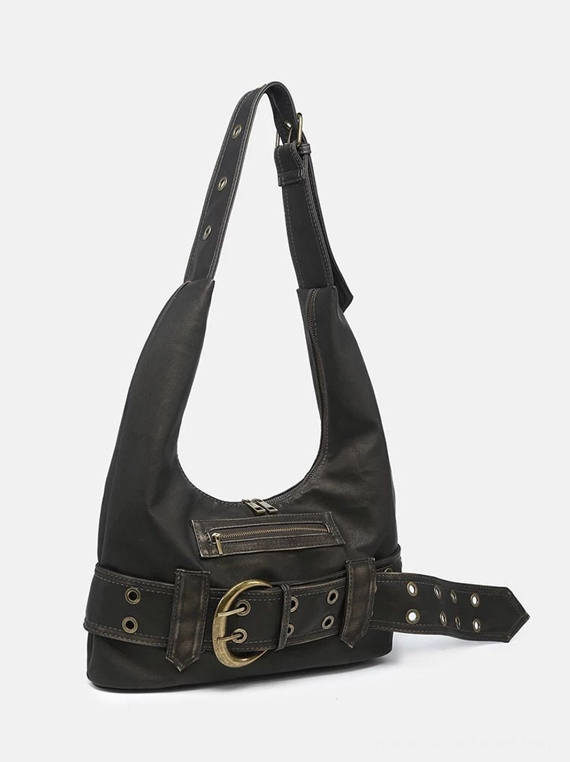 Front product view of black distressed faux leather hobo shoulder bag with crescent silhouette, zipper pocket, grommets, and oversized buckle