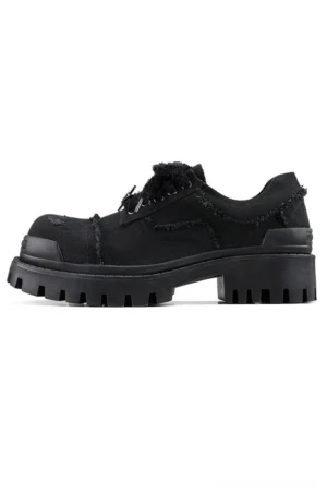 Black distressed canvas platform sneaker in side three-quarter view showing low-top lace-up design and rugged rubber lug outsole