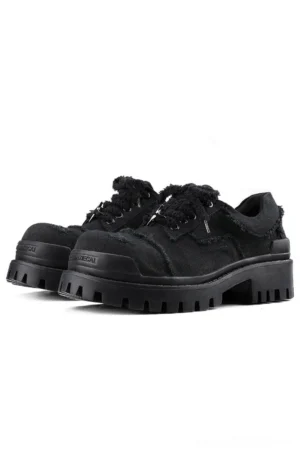 Black distressed canvas platform sneakers pair shown in front three-quarter view with frayed upper and chunky lug sole