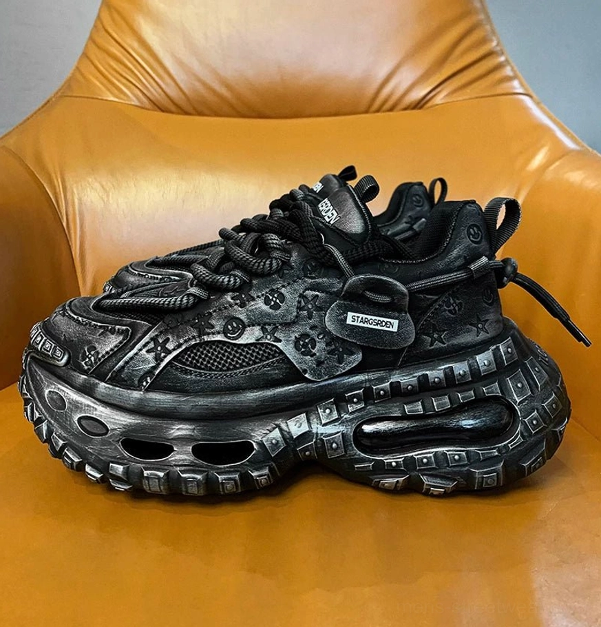 Single black distressed chunky sneaker with embossed star and floral motifs, heavy laces, padded collar, and a carved hollow platform sole