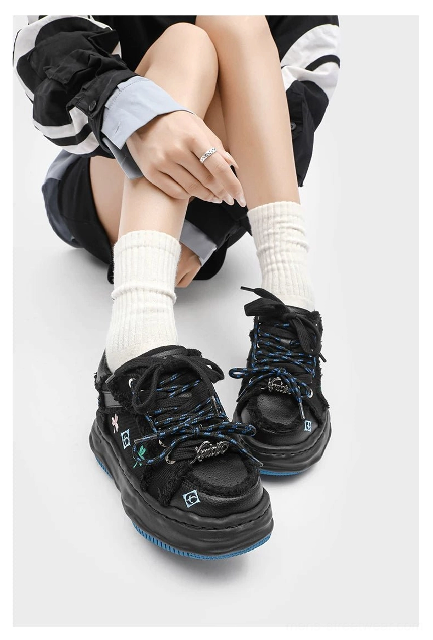 Black distressed embroidered platform sneakers worn with white crew socks showing front and side silhouette