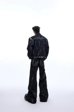 Back view of black distressed wide-leg jeans with metal rivets, rear pockets, brushed wash texture, and raw flared hems