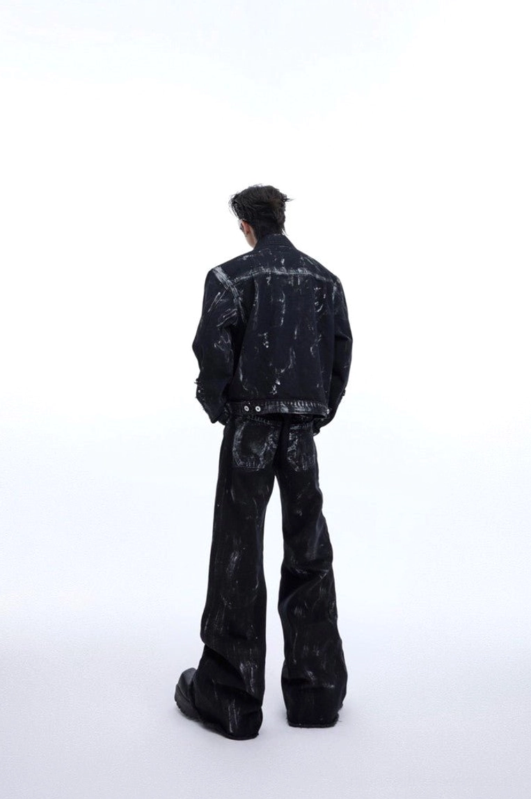 Back view of black distressed wide-leg jeans with metal rivets, rear pockets, brushed wash texture, and raw flared hems