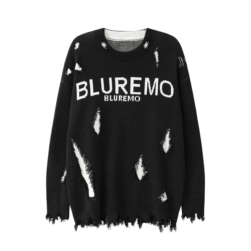 Flat lay front view of a black distressed oversized crewneck sweater with shredded white knit accents, raw hem, and bold chest lettering