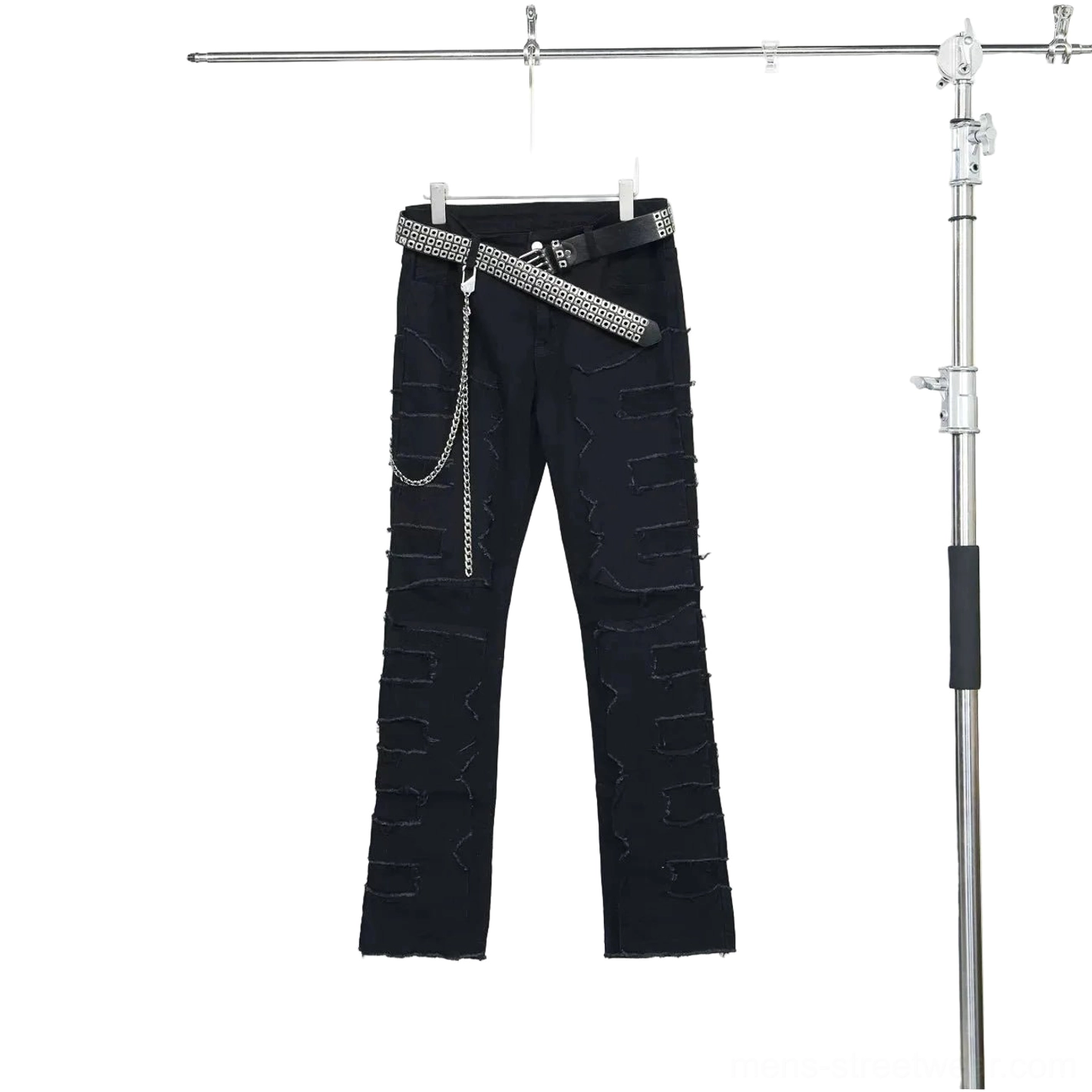 Flat lay front view of black distressed punk jeans with frayed patchwork denim, studded belt, and detachable metal chain
