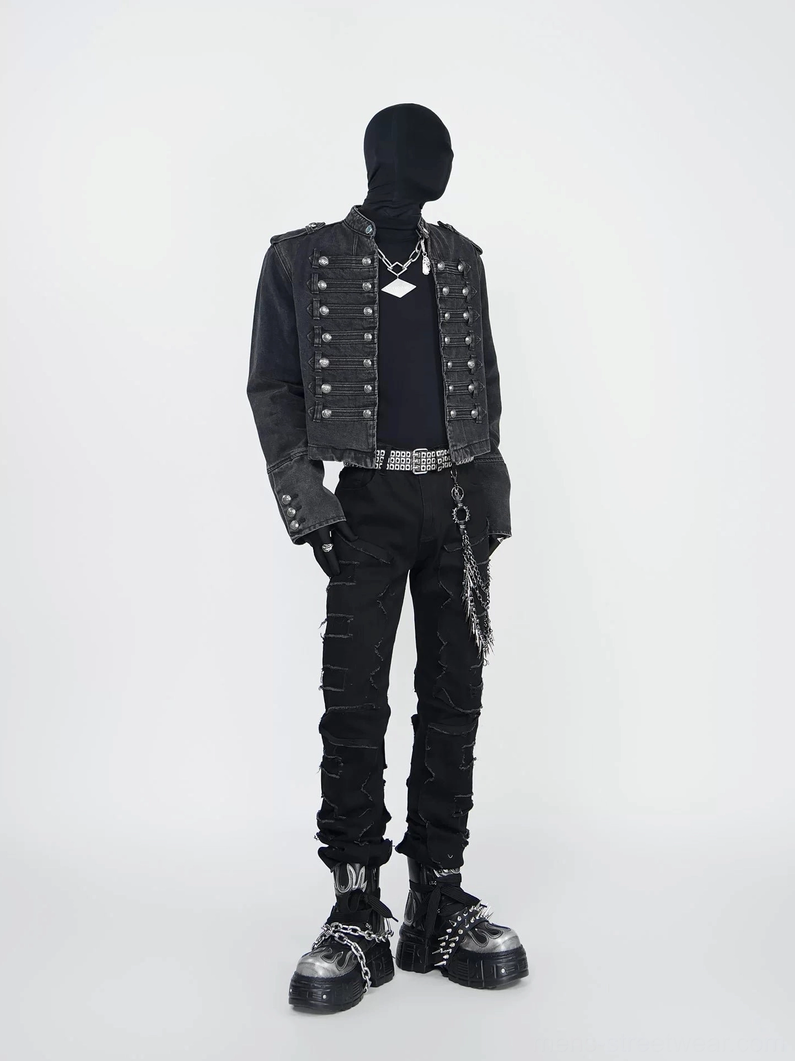 Full front view of black distressed spike chain jeans with shredded denim, stacked slim legs, studded belt, and punk streetwear styling
