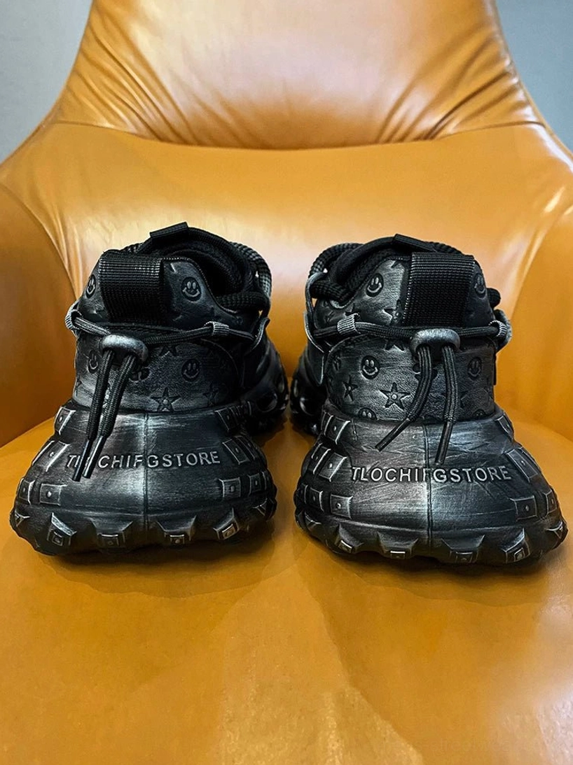Black distressed platform sneakers viewed from the rear showing thick tied laces, textured heel construction, and futuristic hollow rubber soles