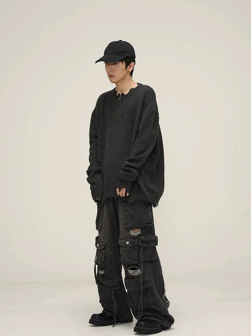 Black distressed wide-leg cargo jeans side view styled with oversized knit sweater, showing baggy denim silhouette and side cargo pocket