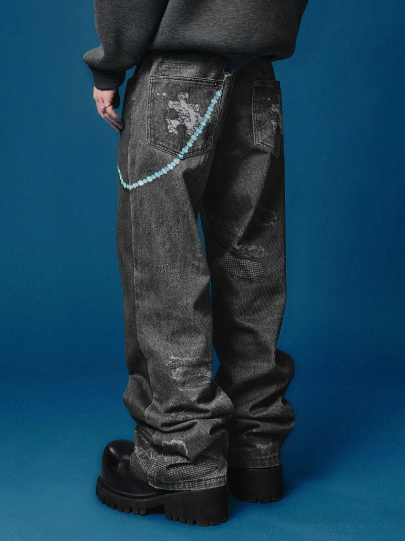Rear view of black distressed wide-leg jeans with splatter-style faded wash, light blue waist chain, sweatshirt, and platform boots