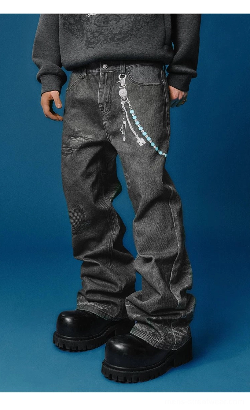 Full front view of black distressed wide-leg jeans with light blue beaded chain, gray graphic sweatshirt, and chunky black boots