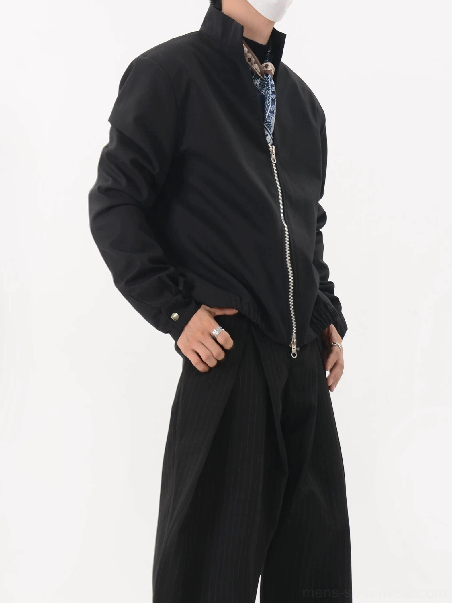 Black double-zip stand collar jacket side three-quarter view with silver zipper and snap-tab cuff detail
