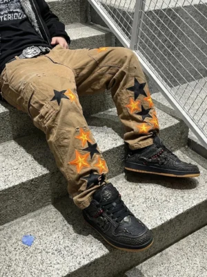 Black dragon embroidered sneakers worn with star-print khaki pants in an outdoor Seoul-inspired streetwear setting