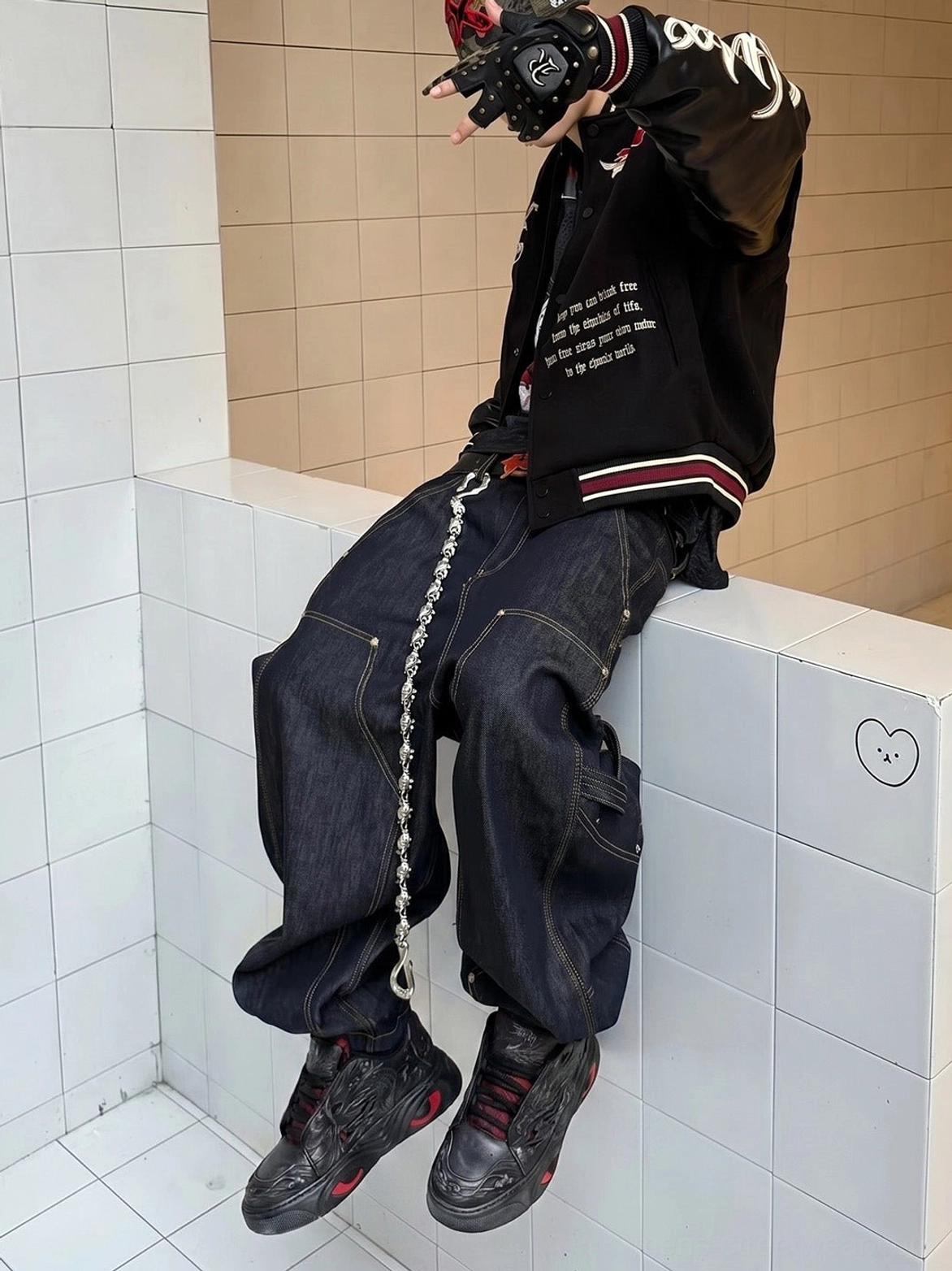 Black dragon relief chunky platform sneakers worn with dark streetwear outfit in overhead seated styling view