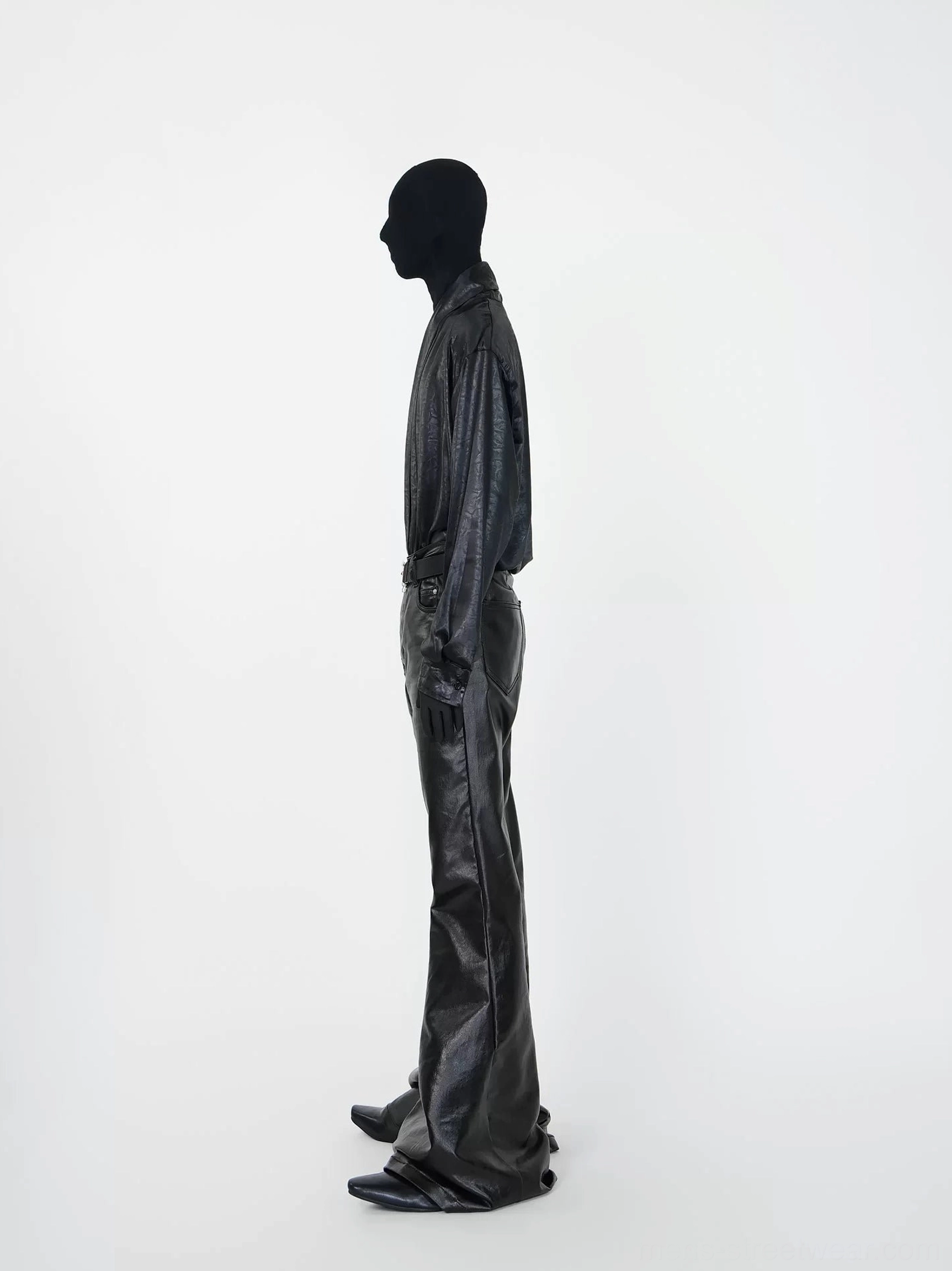 Side profile of relaxed black faux leather long sleeve shirt with draped silhouette and flared pants streetwear outfit