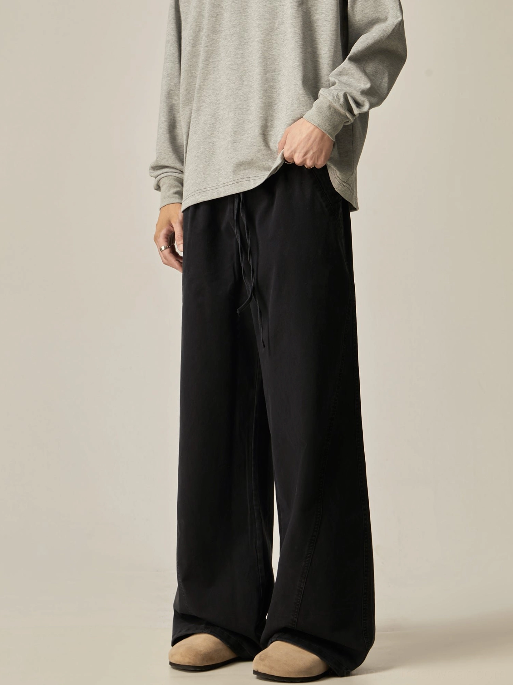 Black loose drawstring wide-leg pants left side three-quarter view solid matte black finish clean stitched seams oversized cut