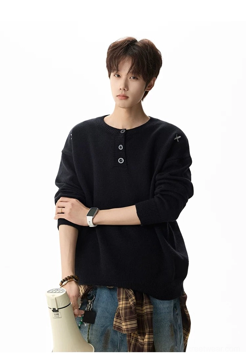 Front view of a solid black drop shoulder henley knit sweater with roomy sleeves and soft warm texture