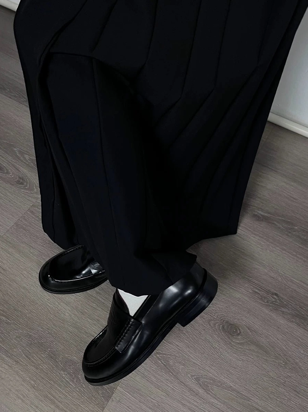Black embossed leather loafers styled with black suit trousers and white socks for a polished formal streetwear outfit