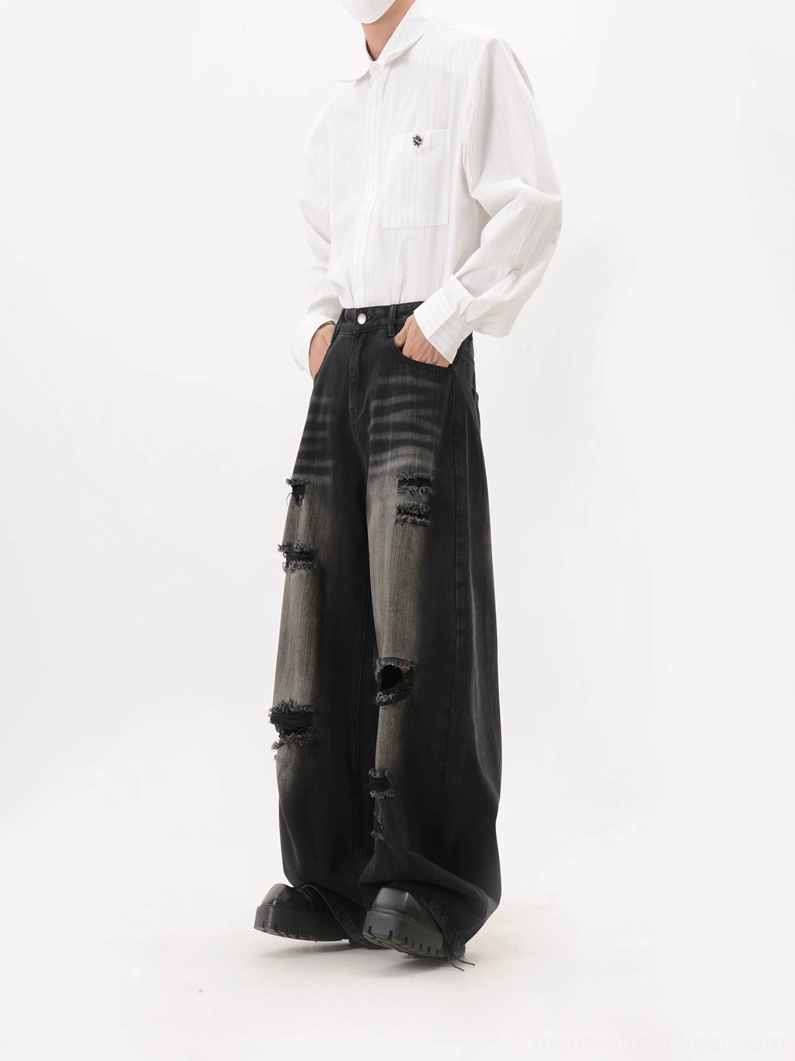 Left side view of black faded ripped wide leg streetwear jeans showing frayed outer thigh cutouts and relaxed oversized fit