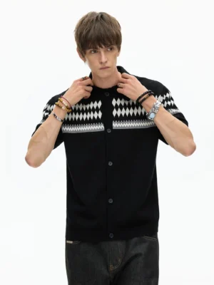 Three-quarter front view of a black Fair Isle knit polo shirt with cream and gray argyle chest pattern styled with dark denim