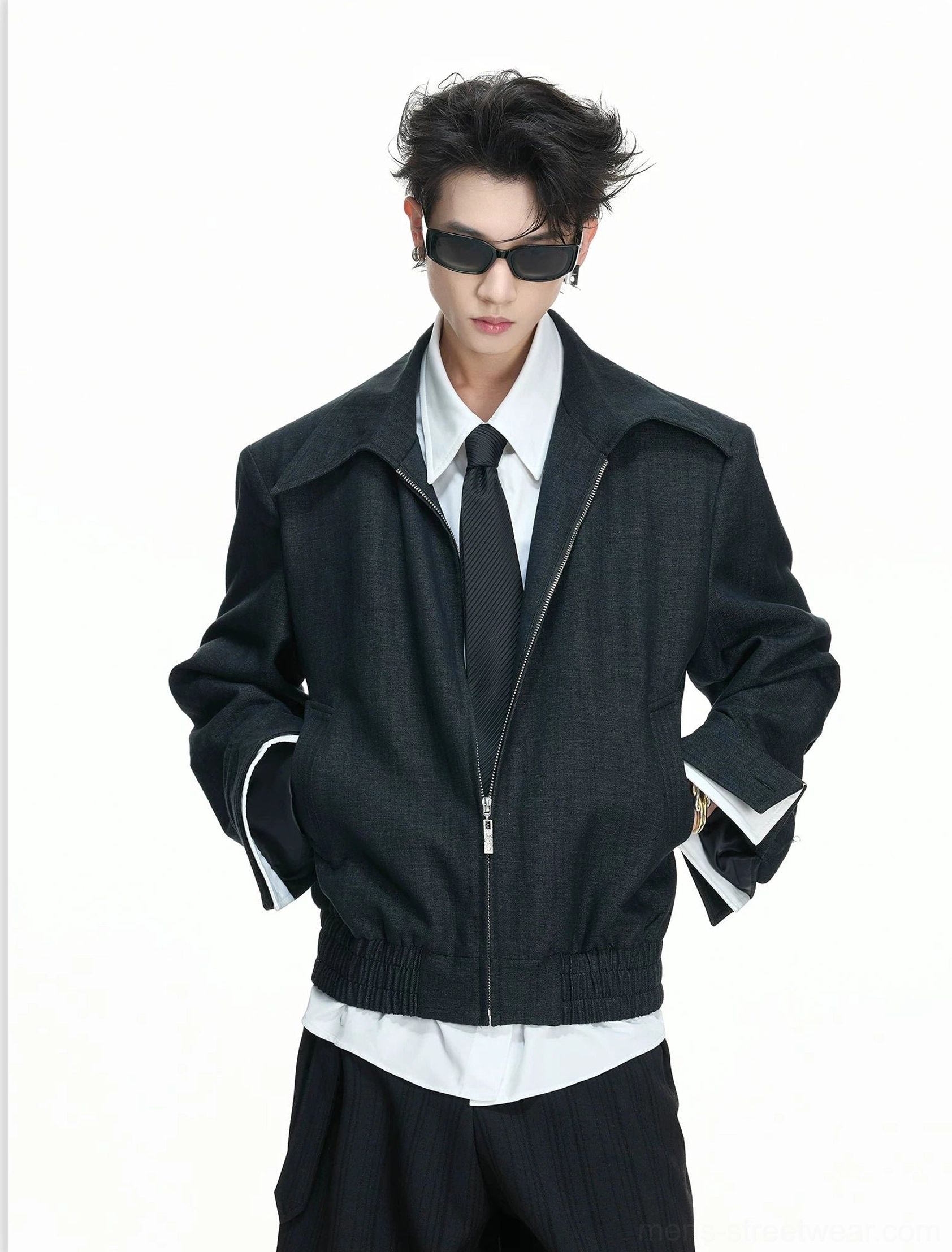 Model wearing a black false-layer zip blouson with a shirt and tie, styled as polished Seoul-inspired men's streetwear