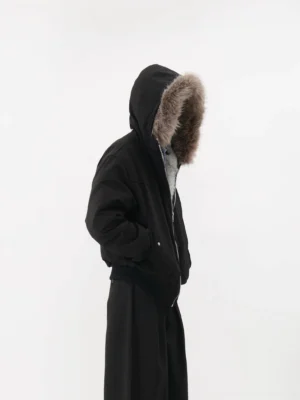 Black faux fur hooded bomber jacket side view showing oversized cropped silhouette and fur-trimmed hood