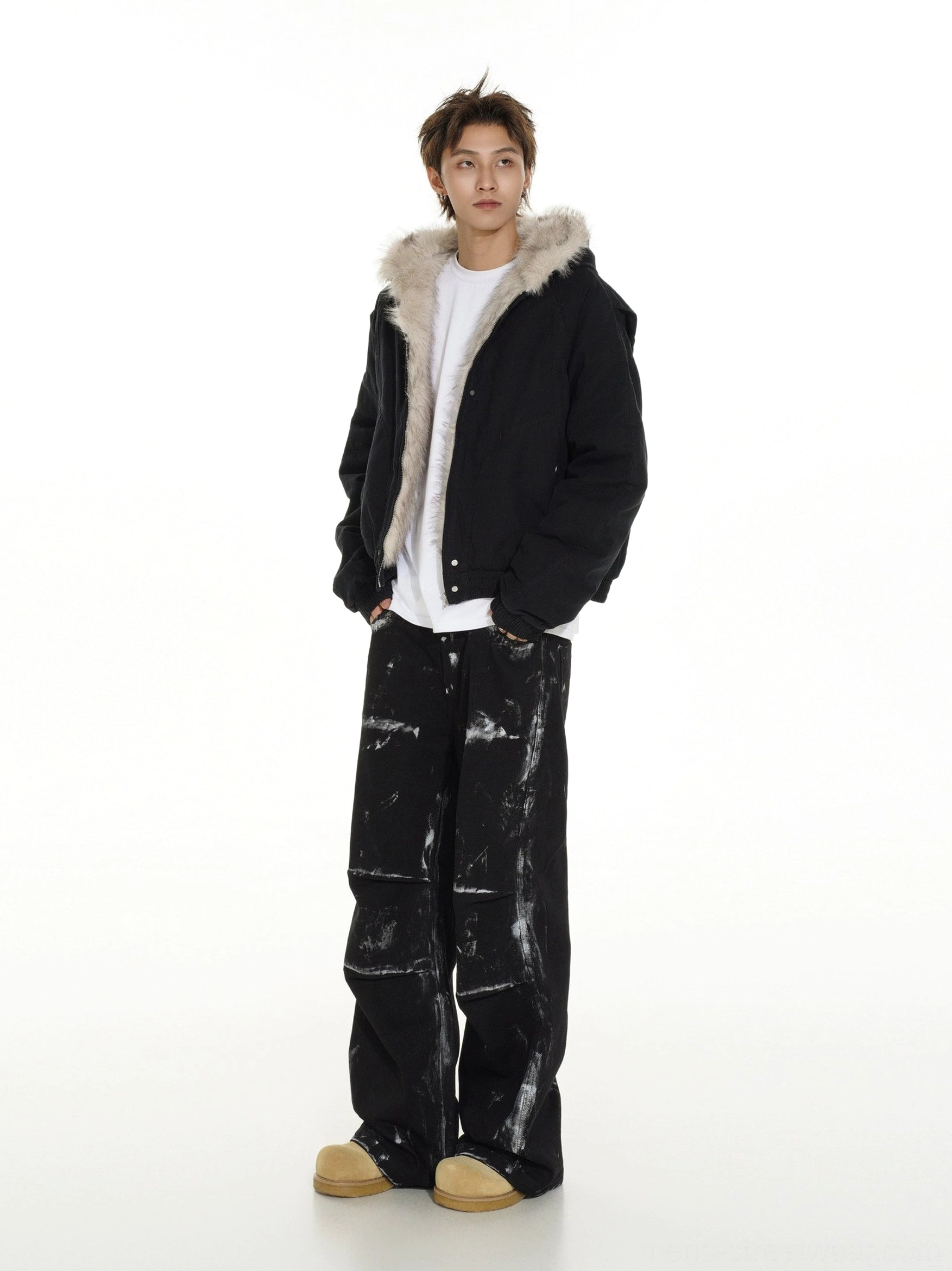 Black faux fur hooded bomber jacket shown from a rear three-quarter angle with cropped streetwear fit and soft fur lining