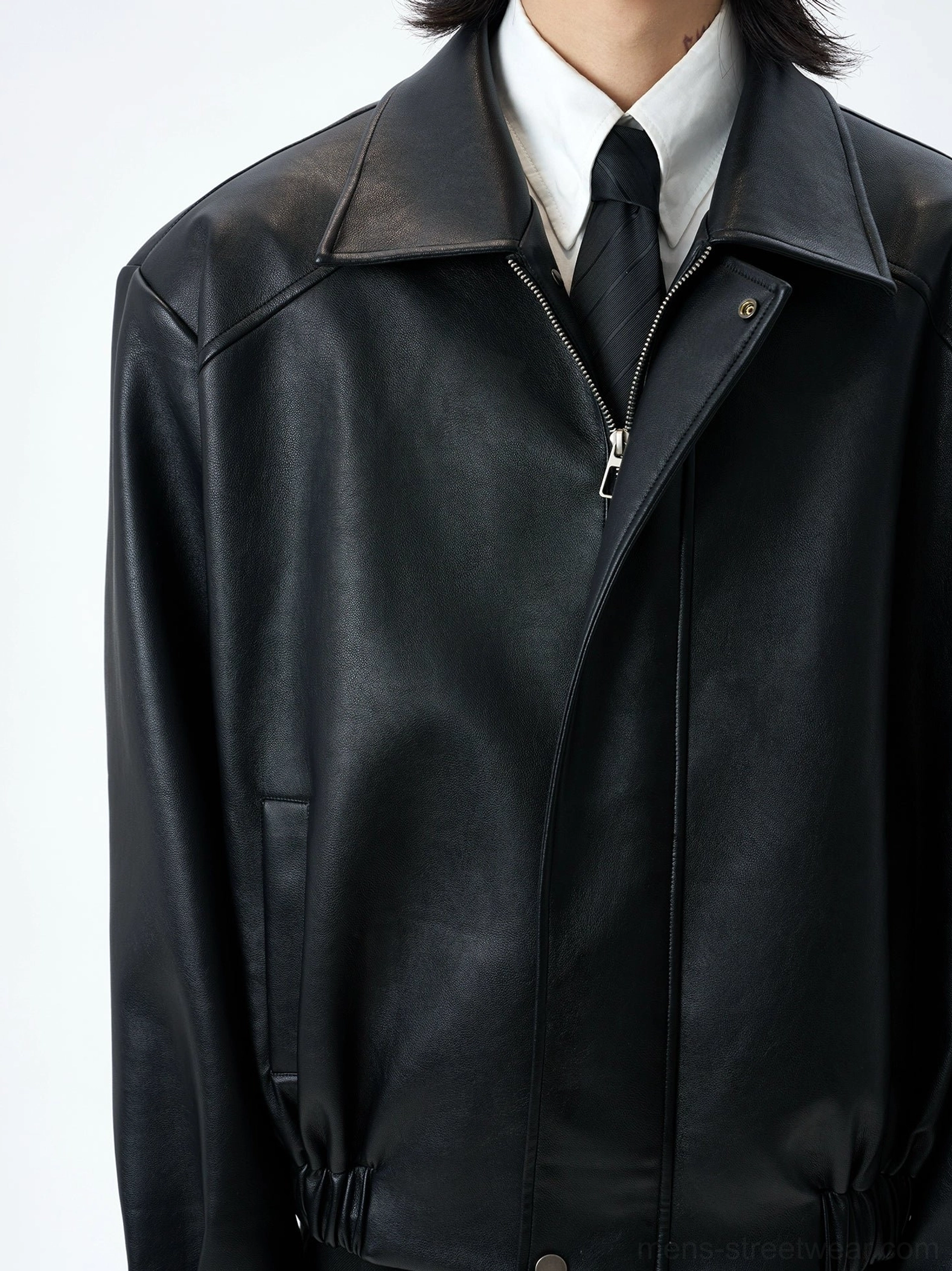 Close up of black faux leather bomber jacket metal zipper notched collar and textured finish