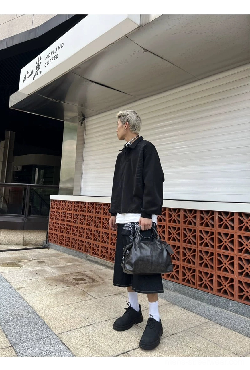 Black faux leather bowling bag carried by hand with a relaxed men's Korean-inspired streetwear outfit