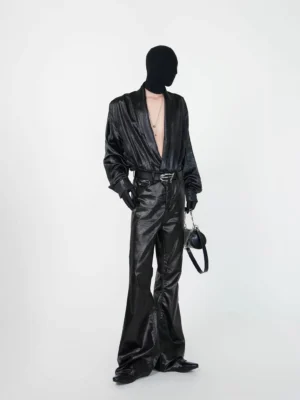 Side three-quarter view of black faux leather draped shirt with deep V neckline layered necklaces gloves and dark streetwear styling