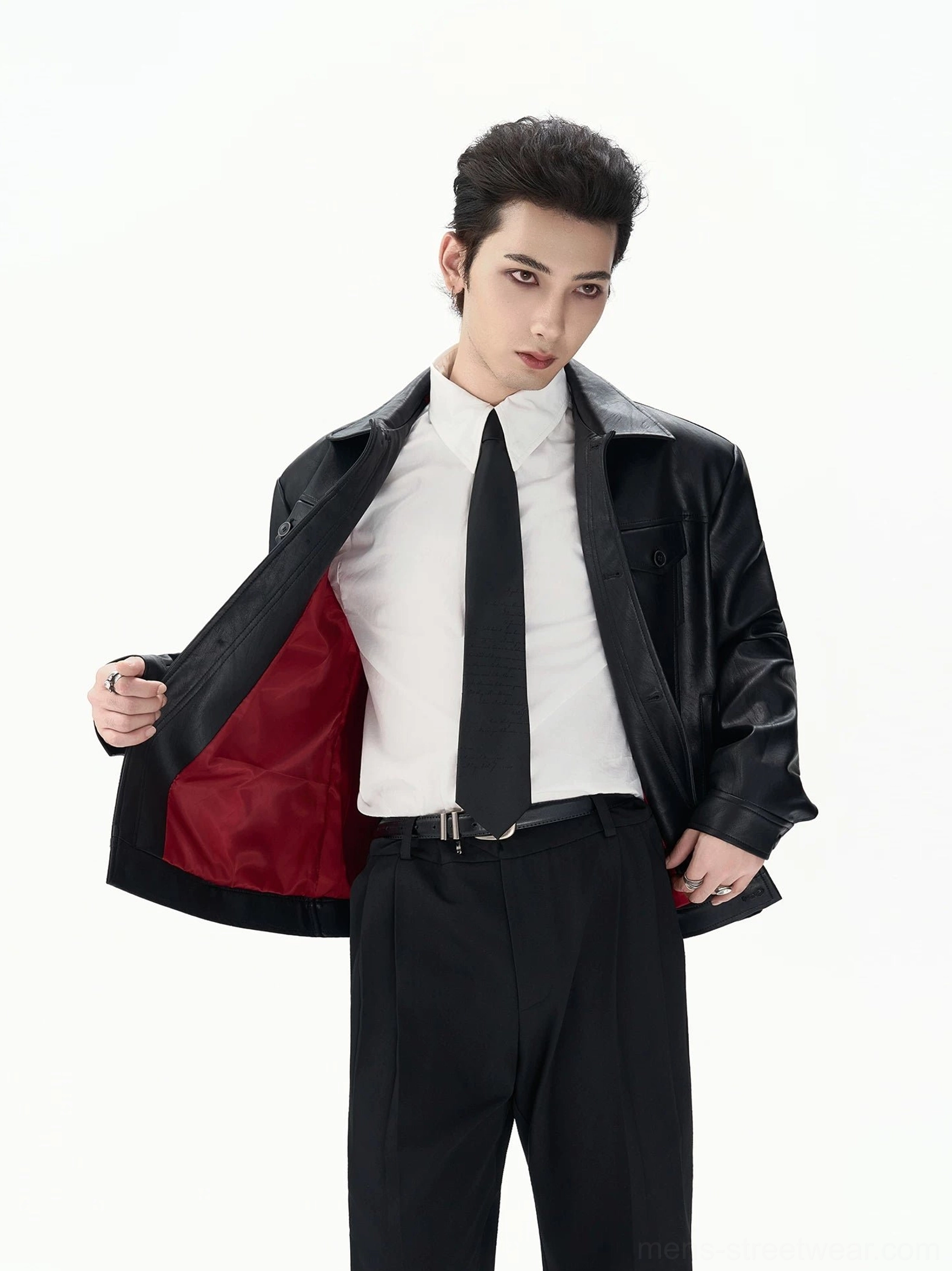 Full-body view of a black faux leather jacket worn partially open to reveal the vivid red full inner lining and structured tailored fit