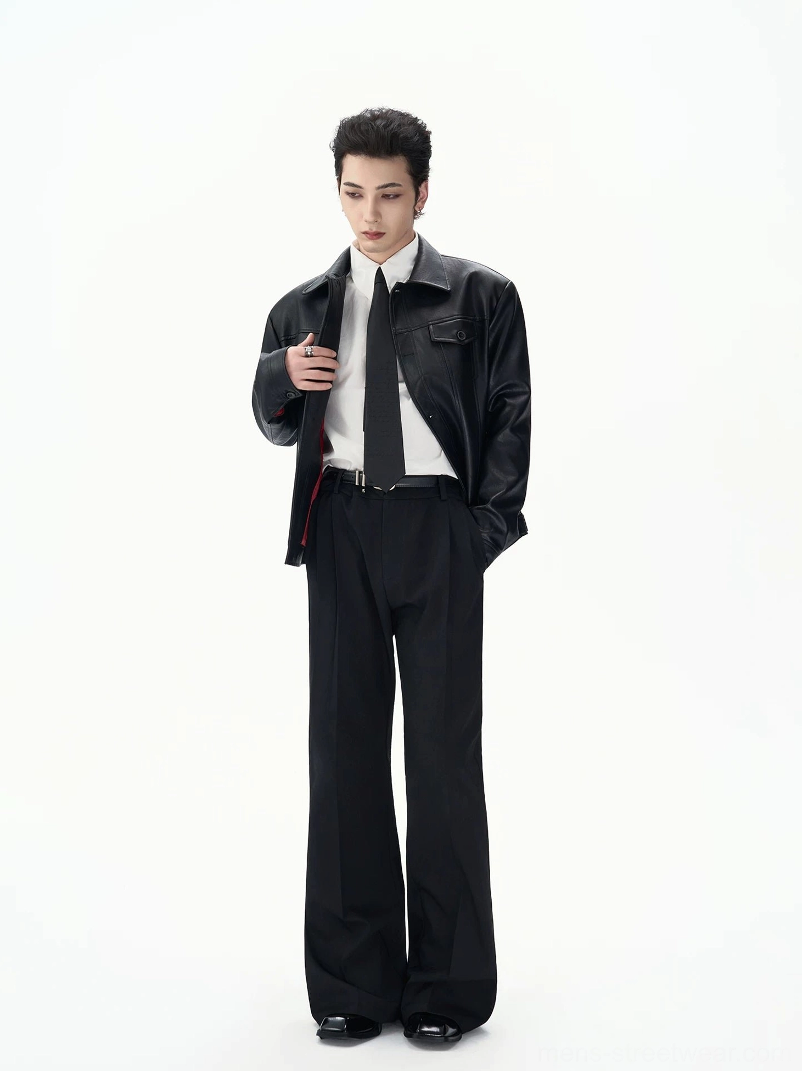 Full-body male model styling a black faux leather jacket with wide-leg black trousers and leather dress shoes in a tailored Seoul streetwear outfit