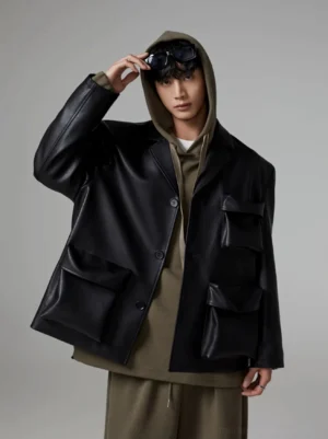 Black faux leather padded pocket blazer styled with an olive hoodie and wide-leg pants in modern Korean streetwear fashion