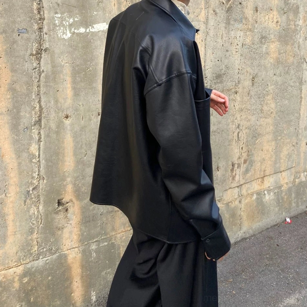 Back side view of black faux leather shirt jacket showing clean back, sleeve construction and matte black PU leather finish