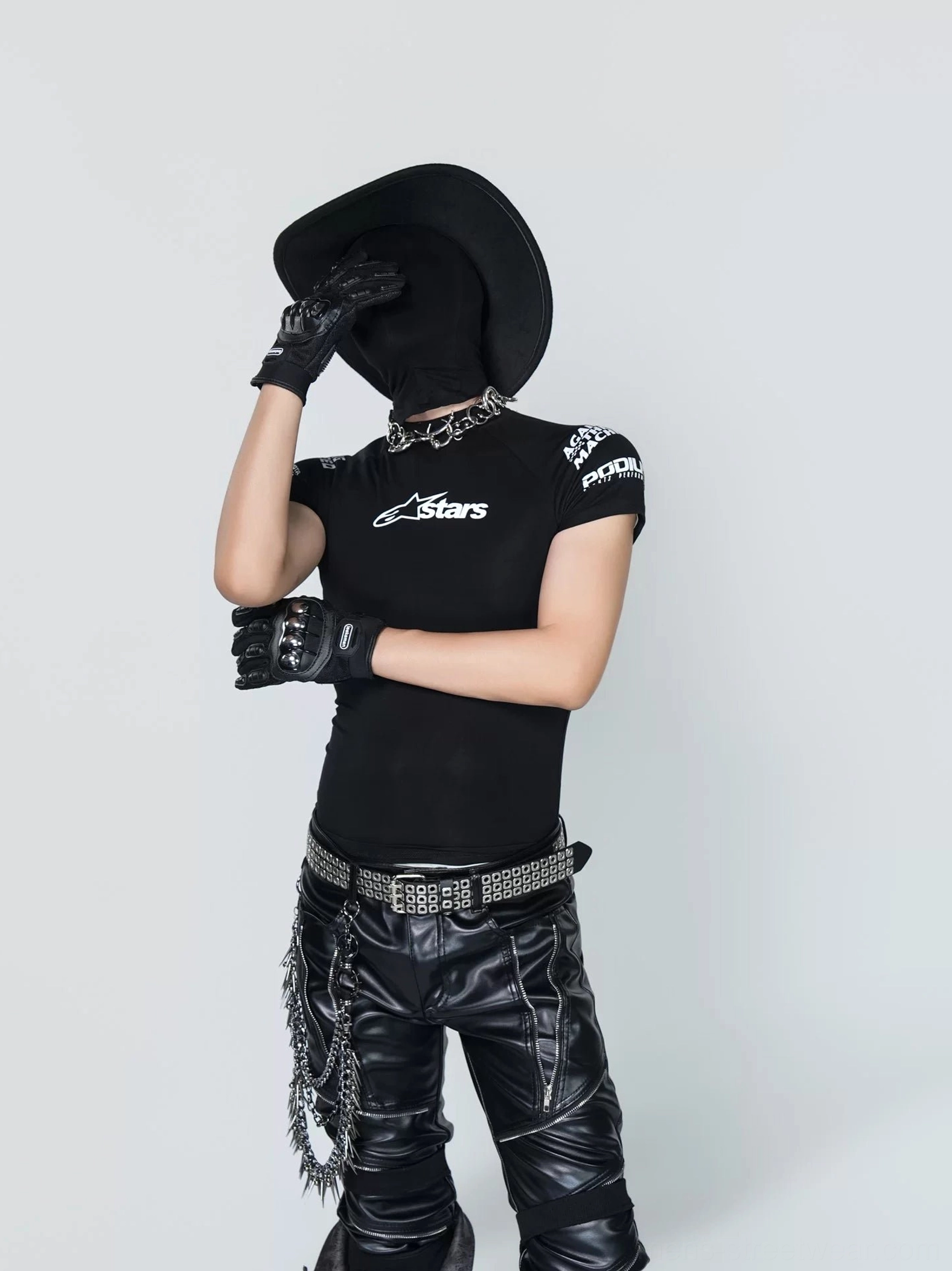 Black fitted racing tee shown from a side angle with shoulder graphics styled with leather biker trousers