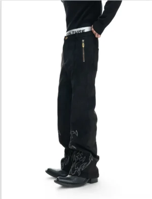 Black flare embroidered trousers shown from the left side with silver-grey flame embroidery, high-waisted wide flare leg, metal side zipper, and modern Seoul streetwear styling