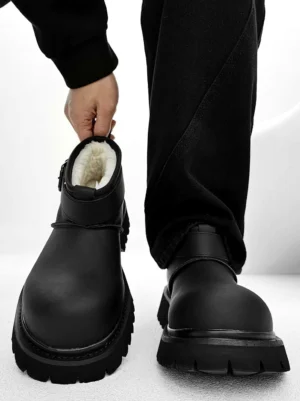 Black fleece-lined chunky platform ankle boots with adjustable buckle strap and deep lug sole styled with black streetwear pants