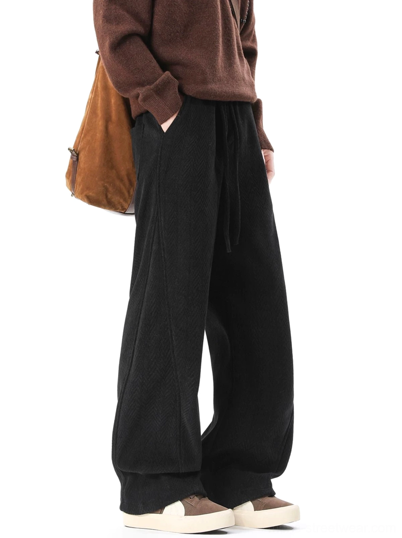 Black fleece-lined herringbone wide-leg trousers in side three-quarter view styled with brown knit sweater and crossbody bag