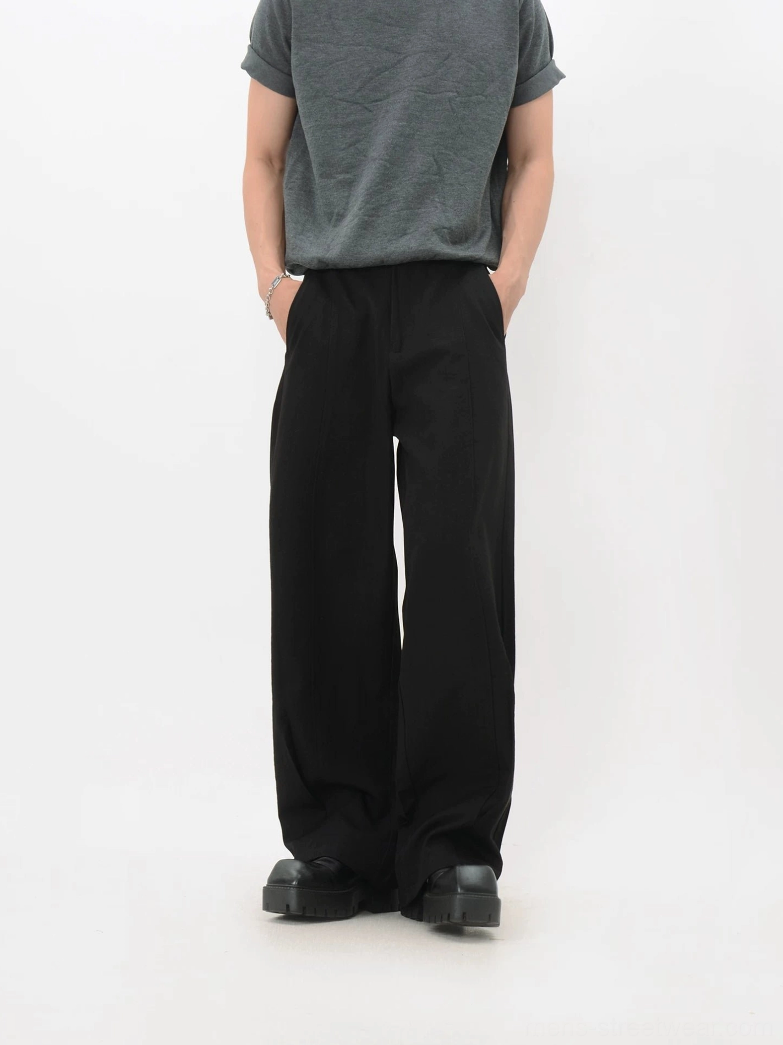 Black fluid wide-leg trousers with a structured waist, front pleats, loose legs, and minimal Korean streetwear styling