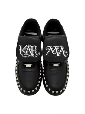 Pair of black foldover tongue chunky leather sneakers with gothic graphic tongues silver rivet details and lace-up streetwear design