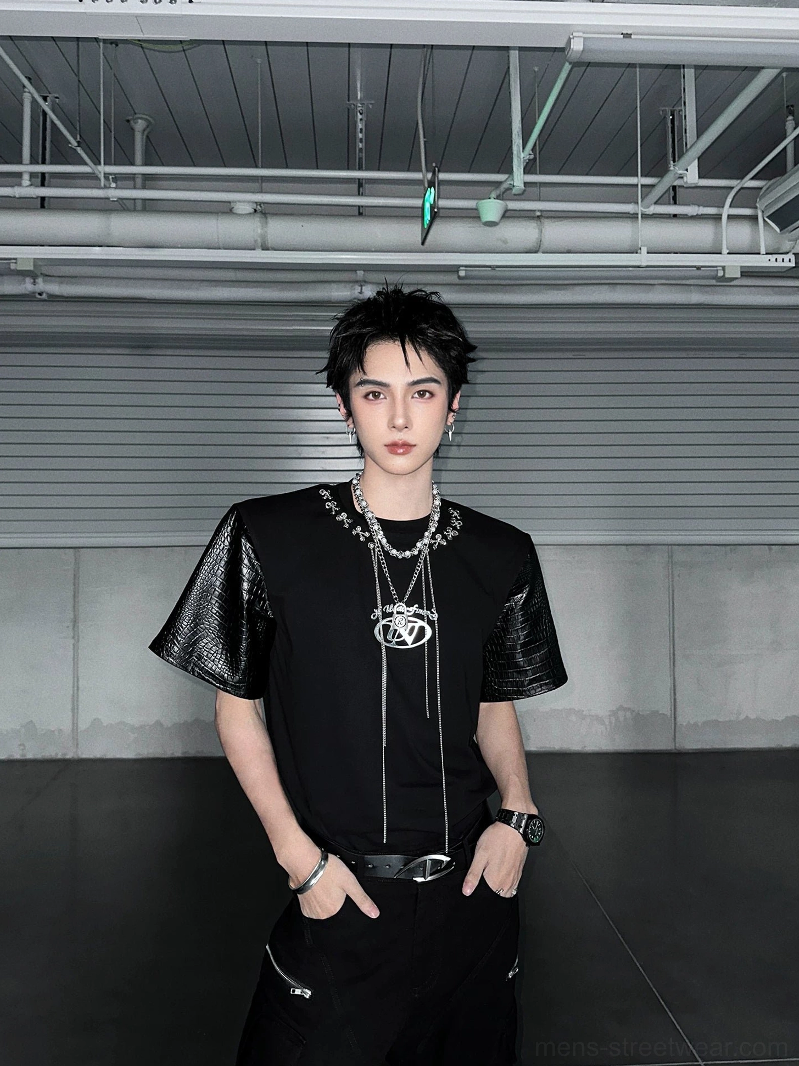 Black futuristic streetwear T-shirt with crocodile-textured faux-leather sleeves, chain laces, cargo pants, watch, and bracelets