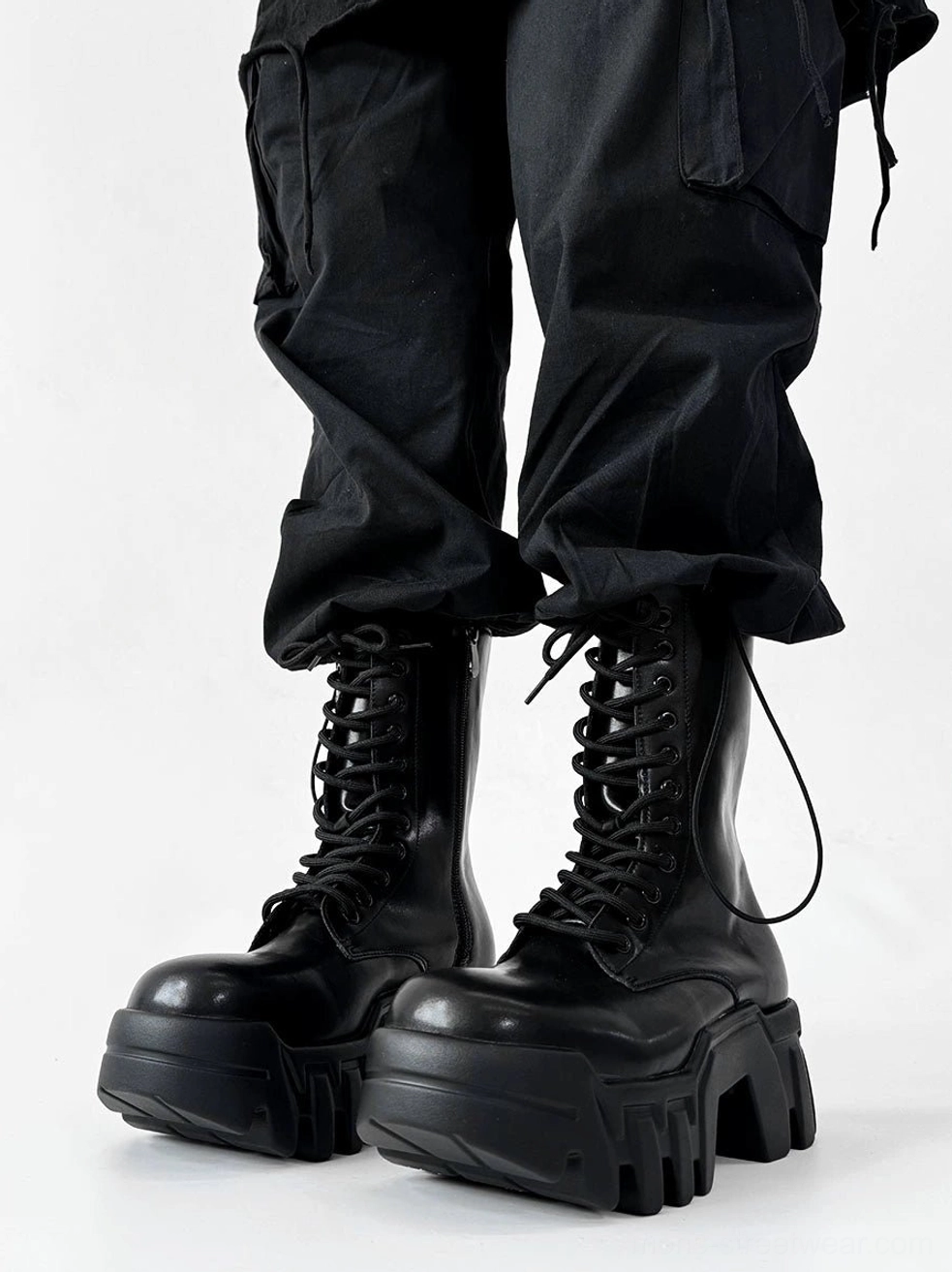 Front close view of black techwear platform combat boots showing round toes heavy lug soles and pull tabs
