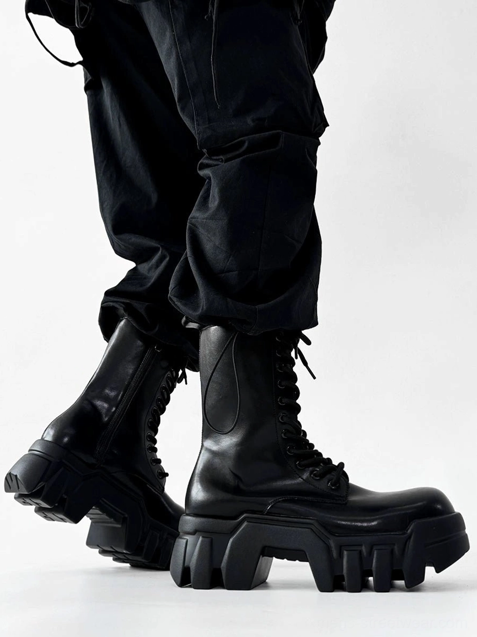 Side three quarter view of black futuristic platform combat boots with lace up closure and thick block heel soles
