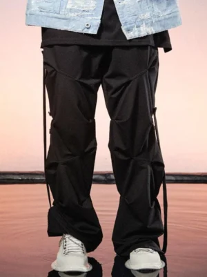 Black geo-sculpt wide-leg pants with ruched leg panels and side drawstring straps styled with a denim jacket and white sneakers