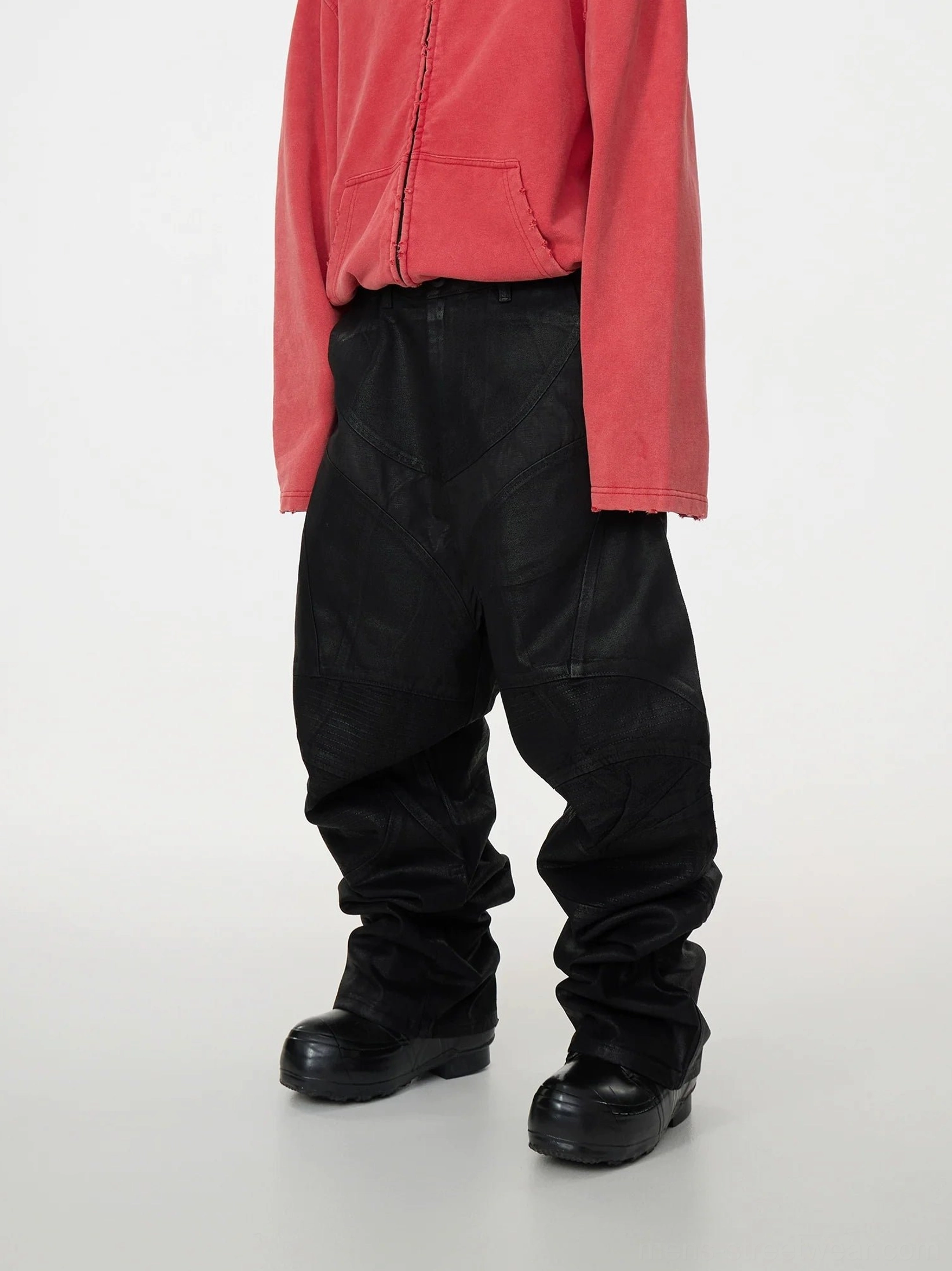 Full front view of black geometric patchwork baggy jeans with matte coated denim, ultra-wide legs, dramatic stacked silhouette, and avant-garde Seoul streetwear styling