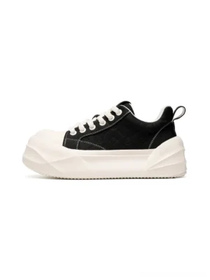 Black geometric platform sneakers shown from the front with tonal stitched panels, white round toe caps, matching laces, and thick 4cm white soles