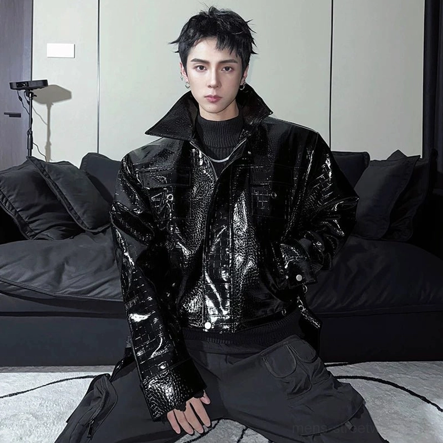 Black glossy crocodile embossed faux leather moto jacket worn by male model in a front three-quarter streetwear portrait