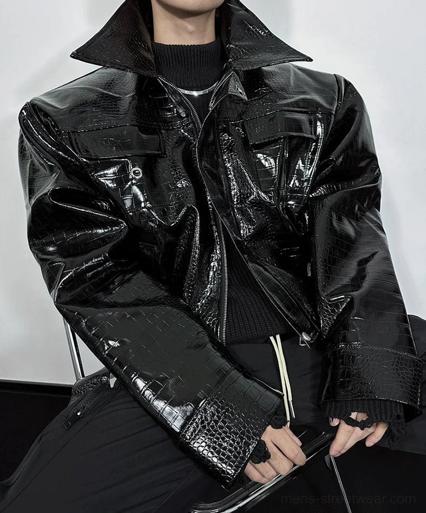 Close-up of black glossy crocodile embossed moto jacket with utility flap pockets and silver snap fasteners