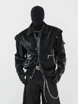 Black glossy faux leather modular biker jacket with notched lapel, zip pockets, snap fasteners, and futuristic streetwear styling on a mannequin