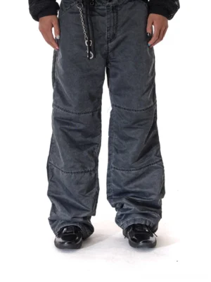 Black glossy retro runner sneakers styled with wide-leg dark cargo pants and a waist chain in a contemporary Seoul streetwear outfit