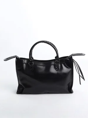 Front view of black glossy structured satchel handbag with rectangular patent faux leather body, buckle handle hardware and side tassel details